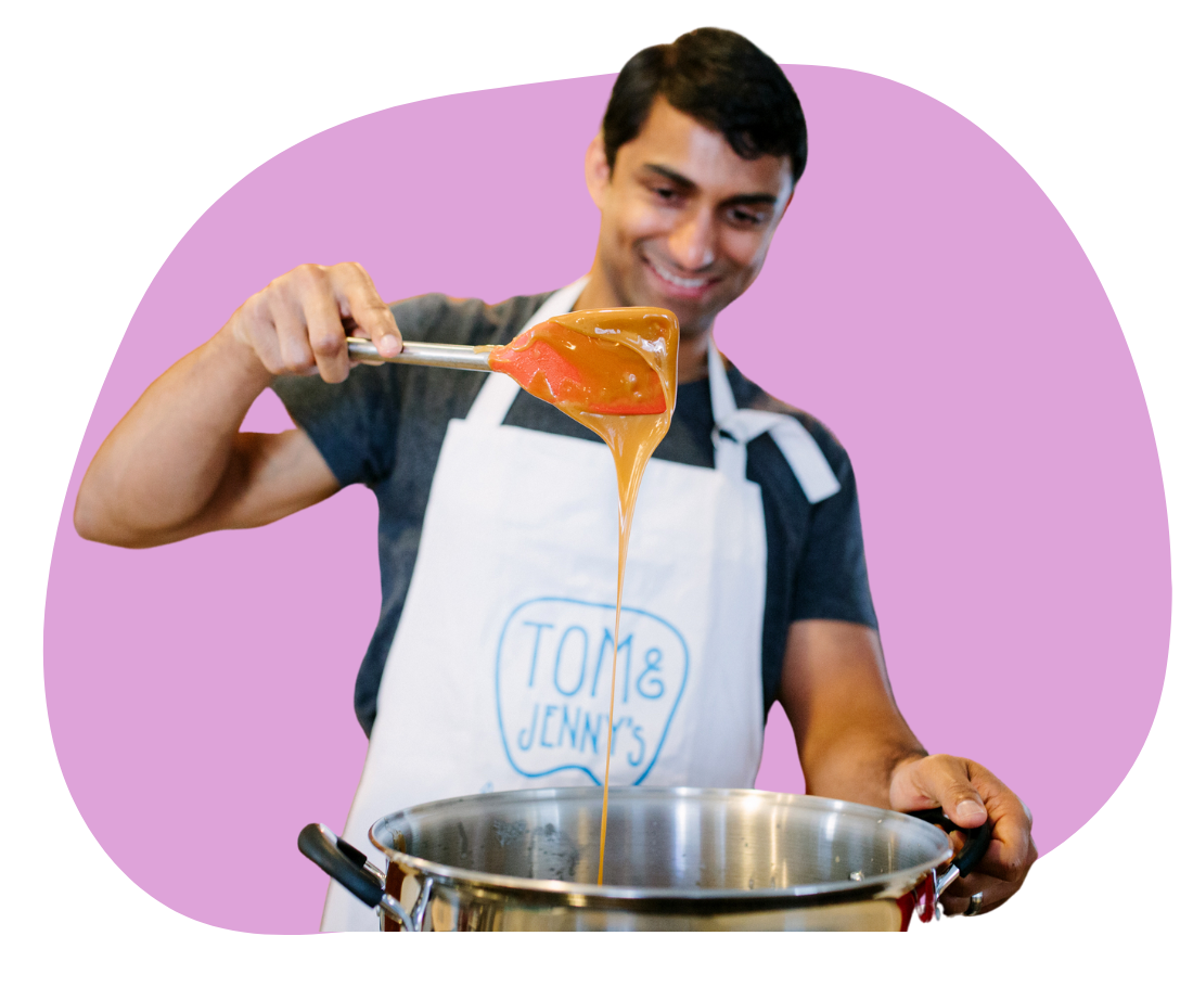 Tommy holding a ladle dripping with caramel