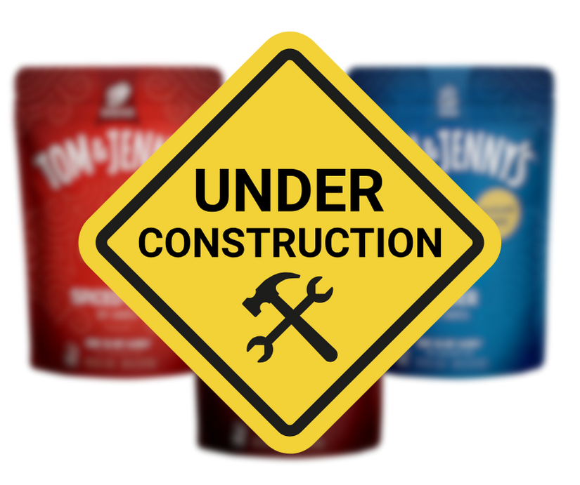 Under construction sign with blurred Tom & Jerry's products in the background