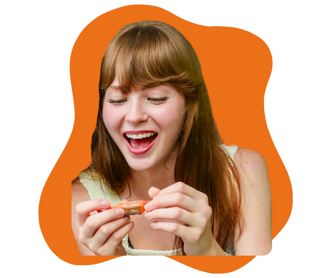 Image of a woman excitedly looking at a piece of Chocolate Tom & Jenny's Caramel