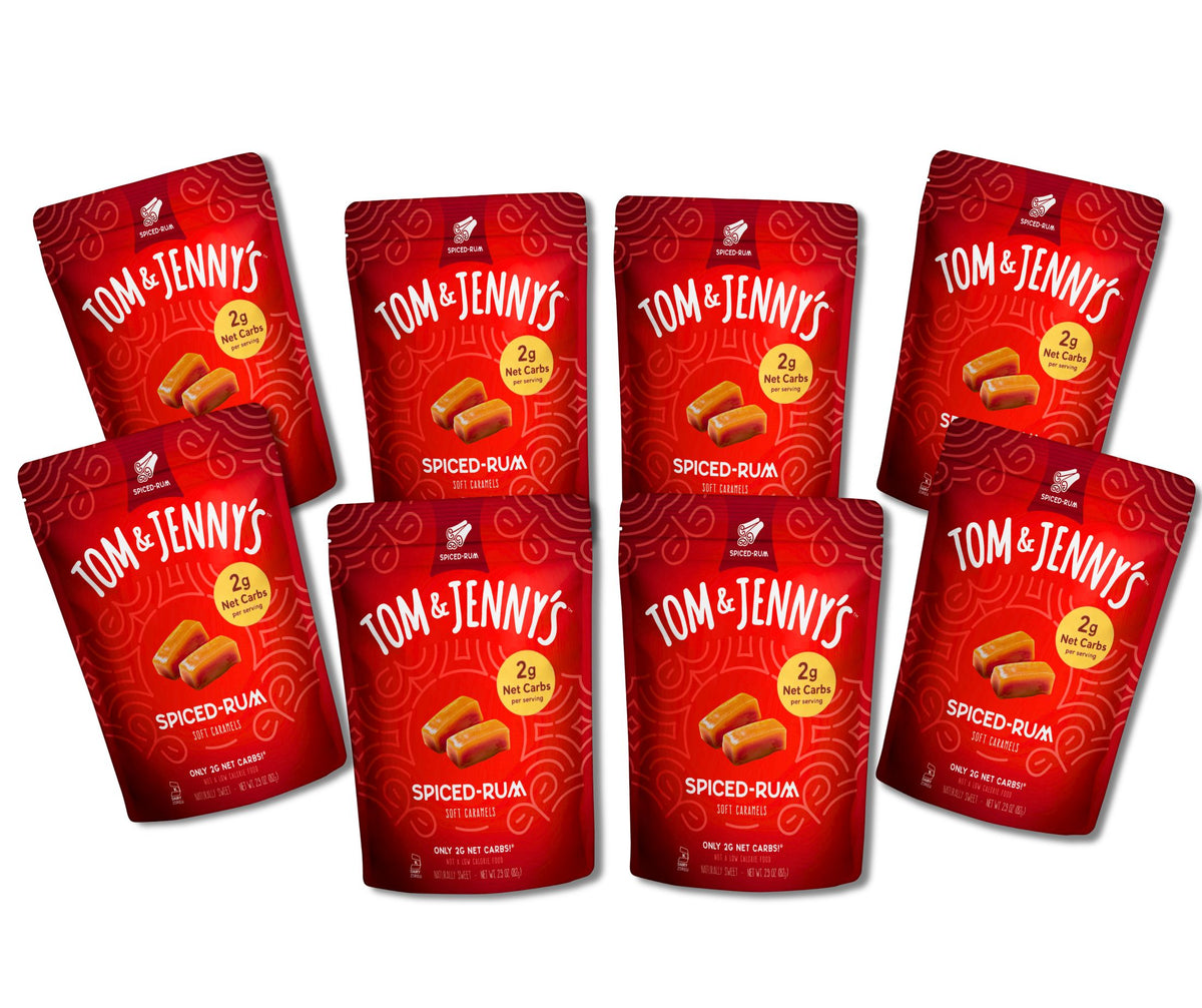 Six red stand-up pouches of Tom & Jenny's Spiced-Rum caramels arranged on a plain white background.