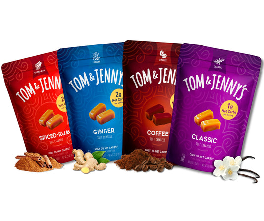 Four stand-up pouches of Tom & Jenny's caramel candies in different flavors (Spiced Rum, Ginger, Coffee, and Classic) arranged in a row with their respective flavor ingredients (cinnamon, ginger, coffee beans, vanilla beans) on a white background.